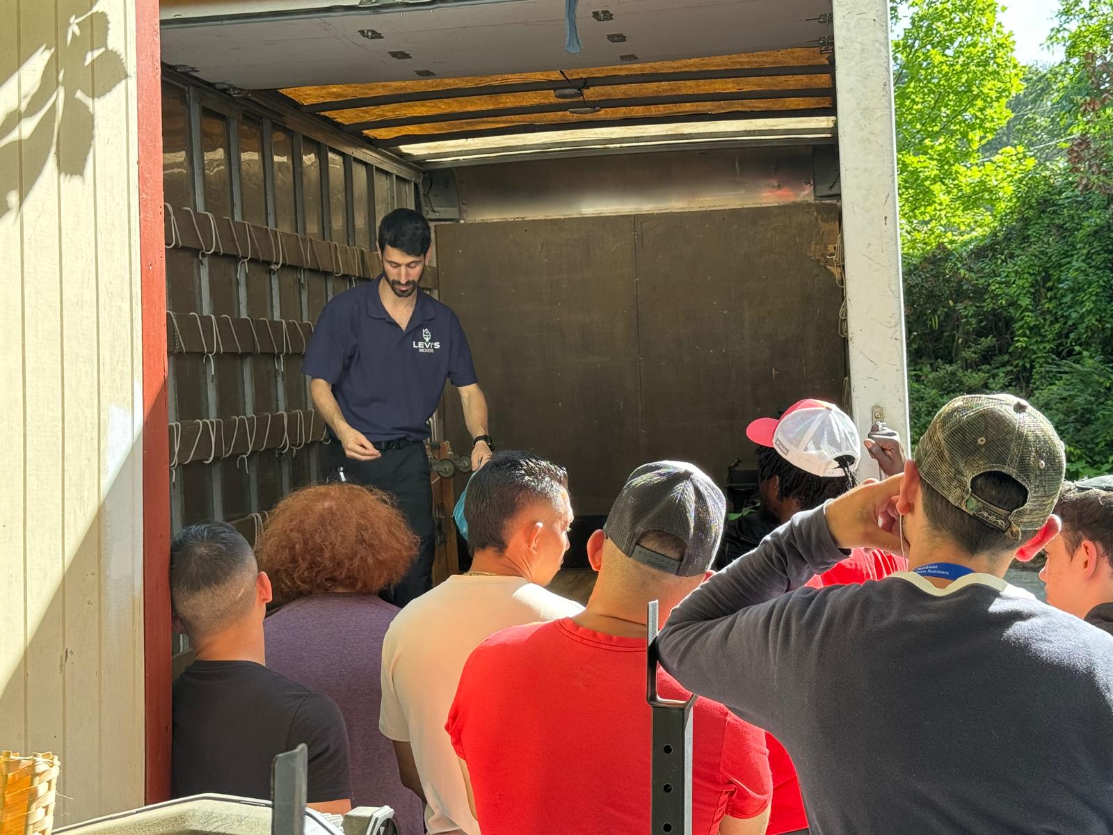 Movers being briefed at the back of a truck