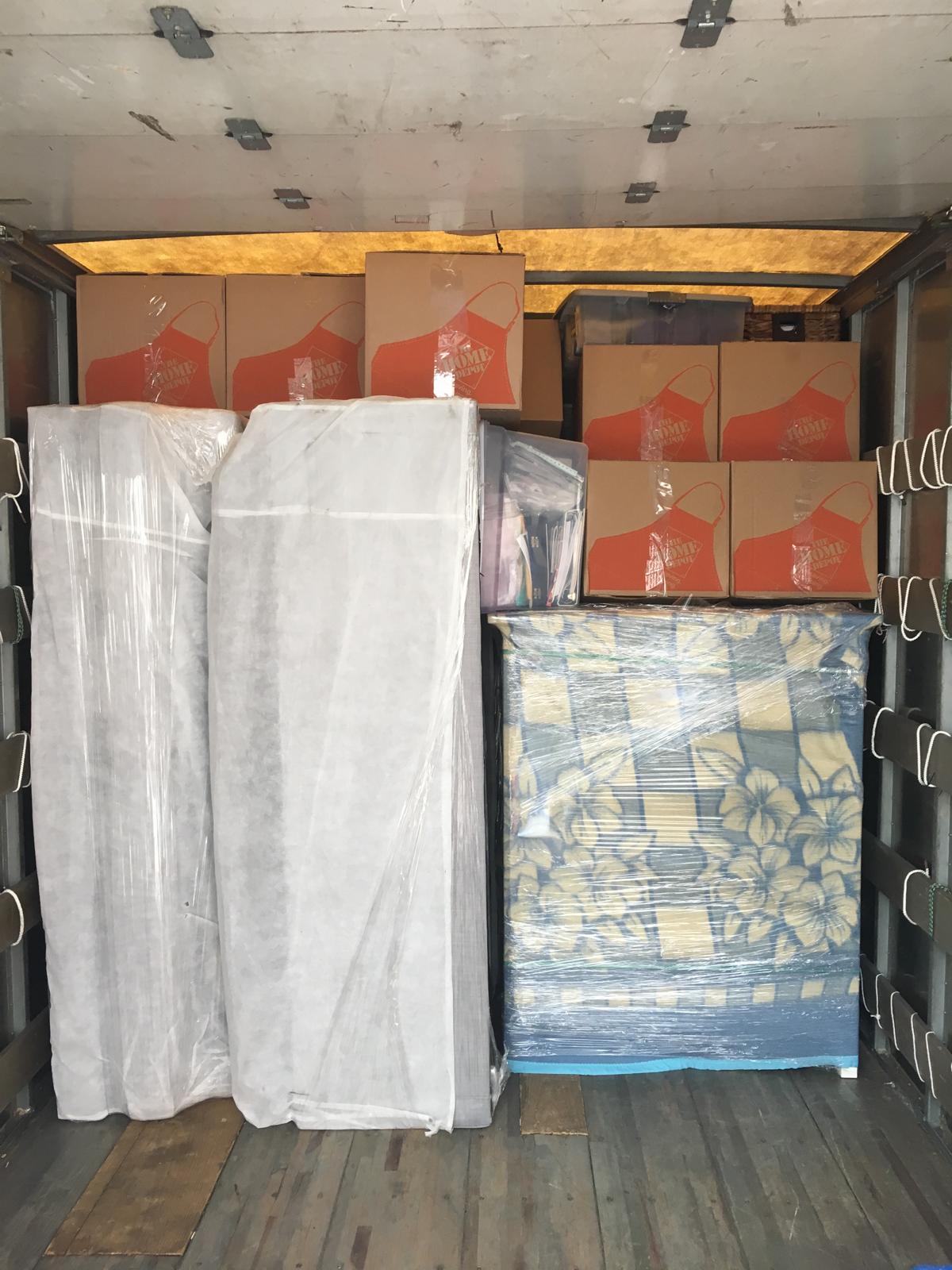 Boxes and furniture packed and wrapped in a moving truck